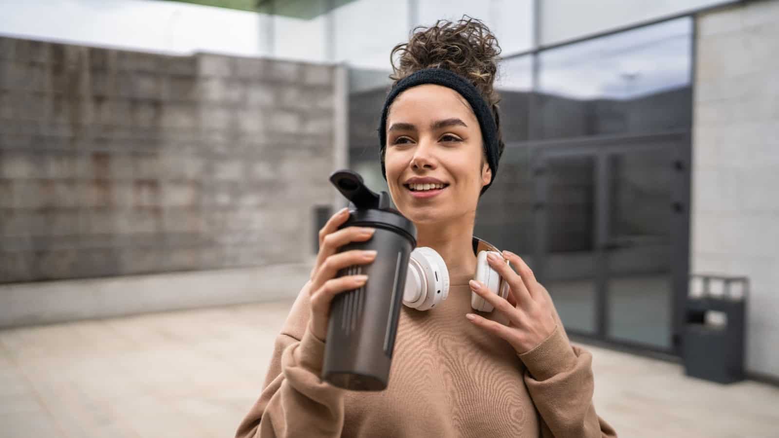 woman athlete drinking protein shake. Smoothie.