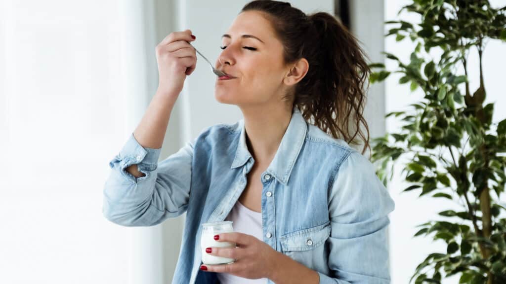 woman eating and enjoying yogurt.