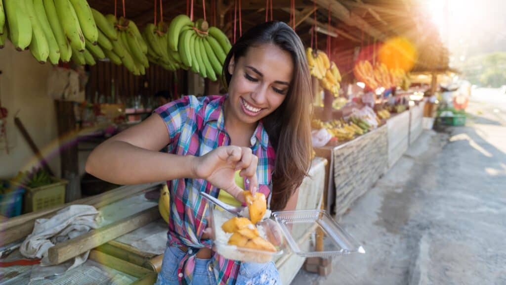 woman eating at a food stall.