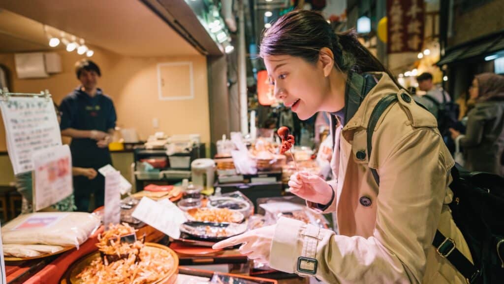 woman eating at food stall.