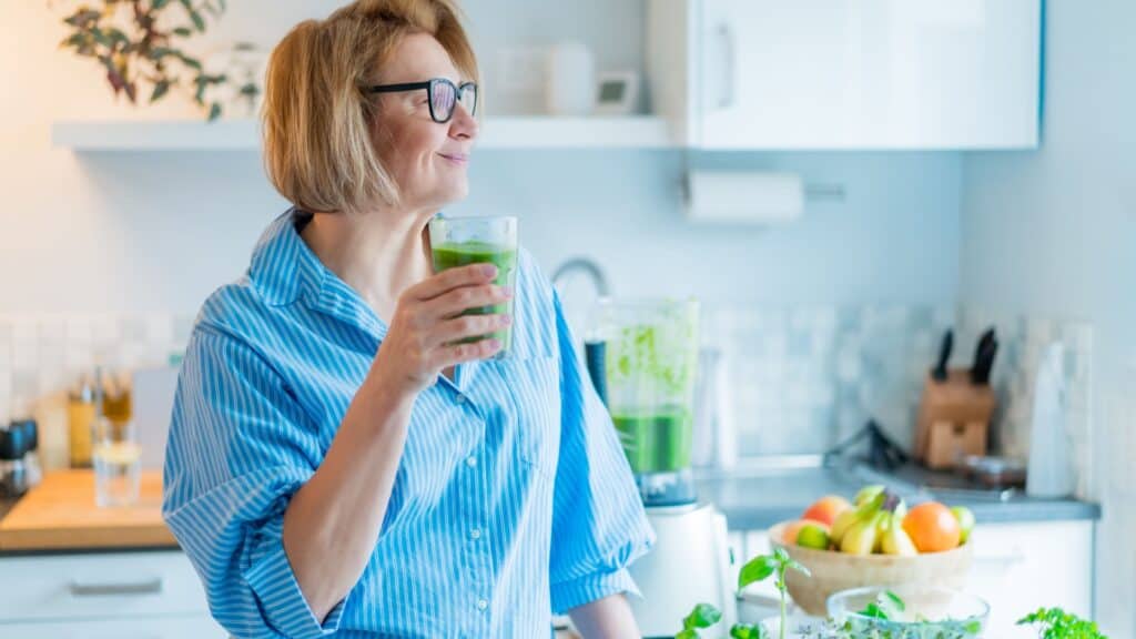 woman enjoying green smoothie. 