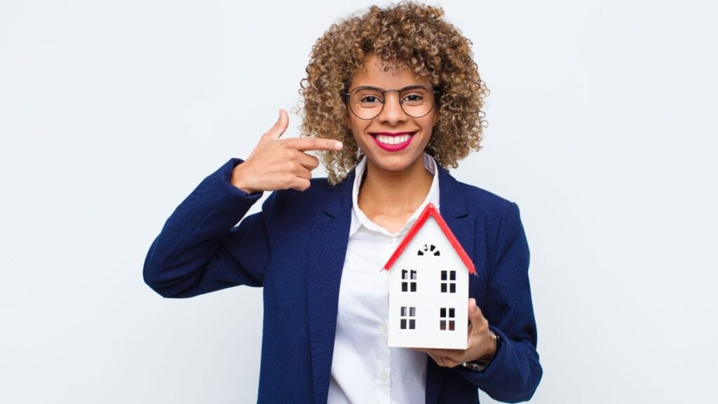 woman pointing to model of house. 
