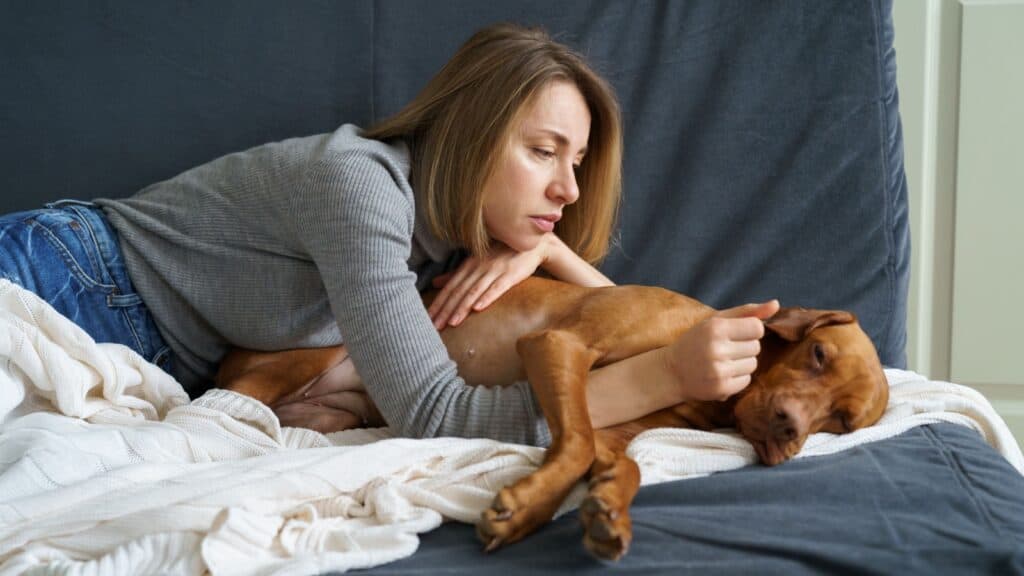 woman tending to sick dog. 