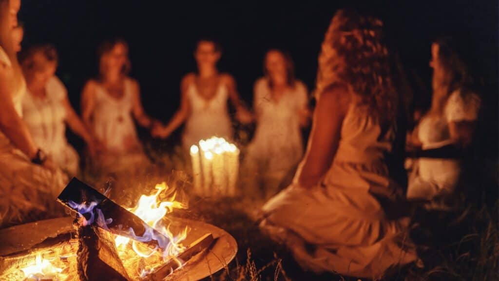women around a fire at night. 