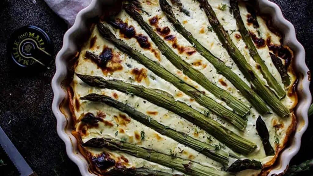 Asparagus-Quiche-in-a-Pie-Pan-After-Baking-Next-to-Eggs-and-a-Knife.jpg.