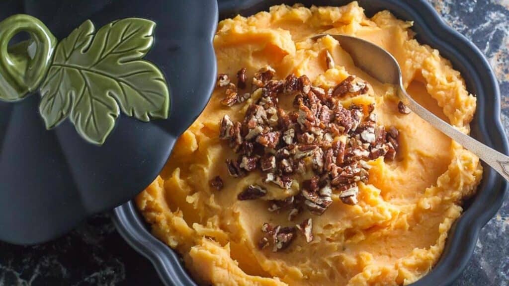 Mashed-Sweet-Potatoes-with-Candied-Spiced-Pecans-in-a-dark-casserole-dish-2.
