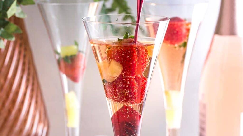 Pineapple-Strawberry-Prosecco-in-champagne-glass-with-red-stirrer.