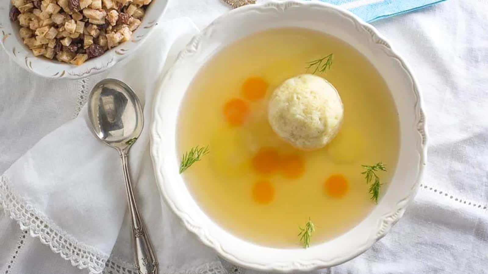 Matzo-ball-soup-in-a-white-bowl-with-charoset-in-the-background-1.