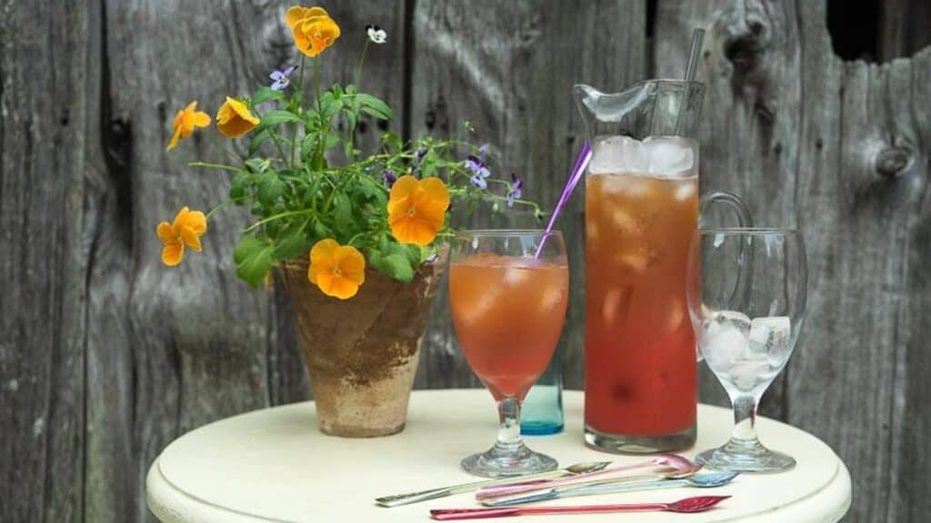 Strawberry-Arnold-Palmer-in-glass-pitcher-and-glass-against-barn-board.