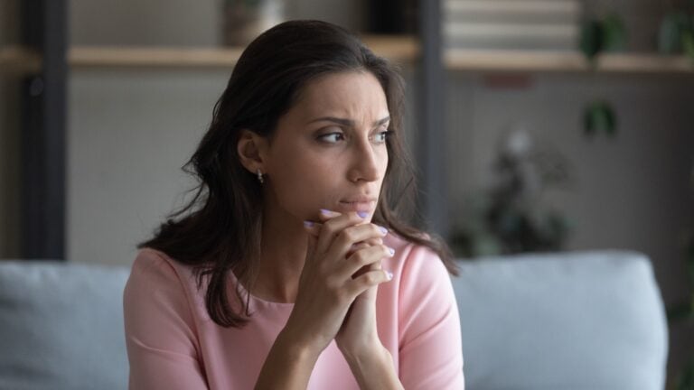 Young woman looking sad and worried. Thinking. Thoughtful.