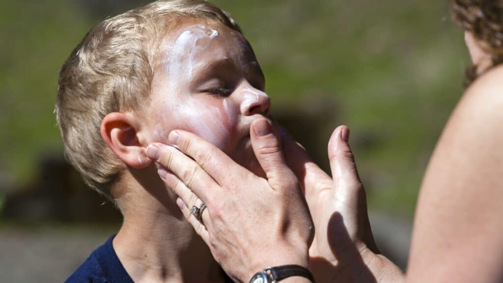 applying sunscreen on child.