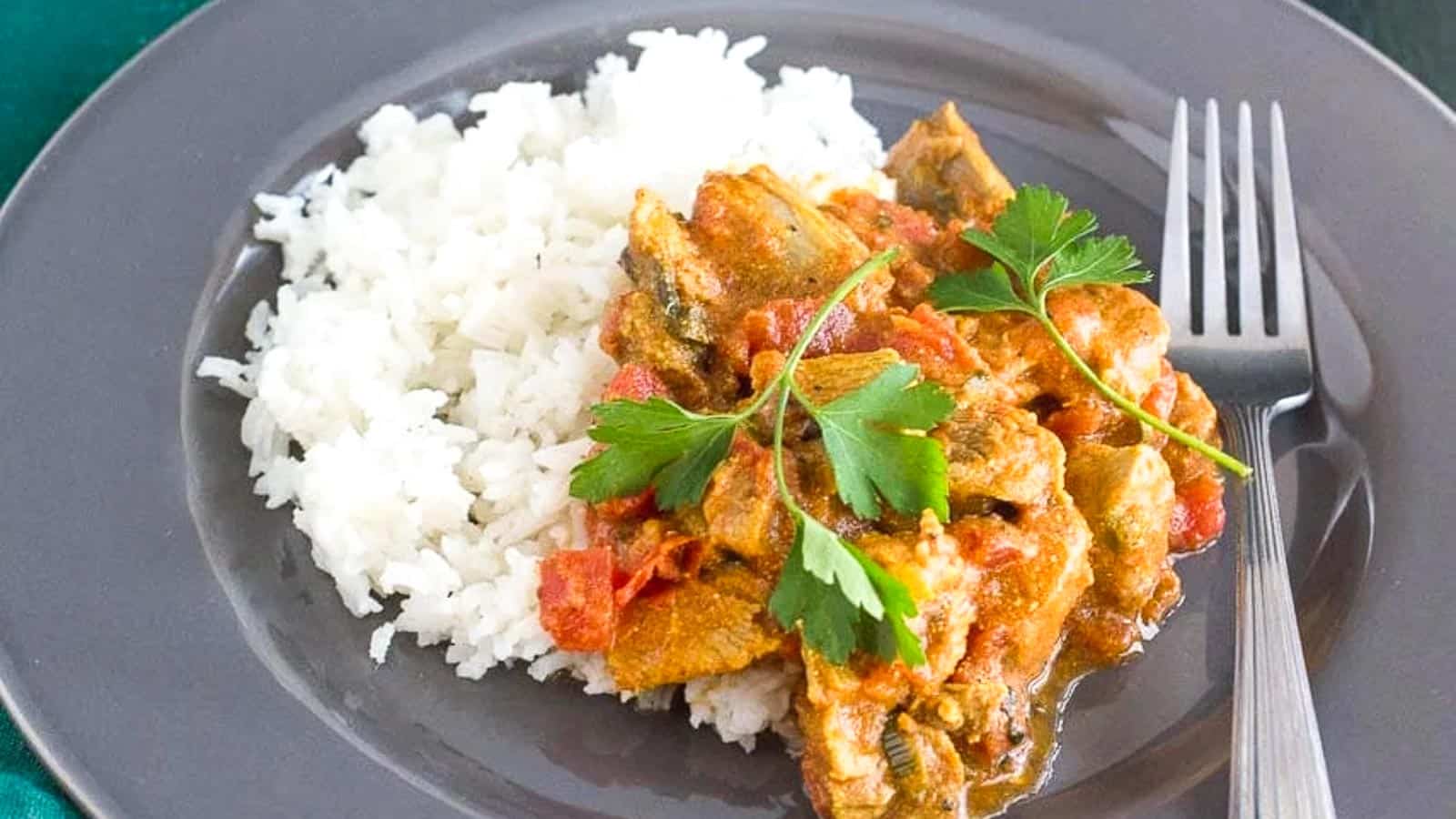 lamb-curry-and-basmati-rice-on-a-gray-plate-with-fork-alongside.