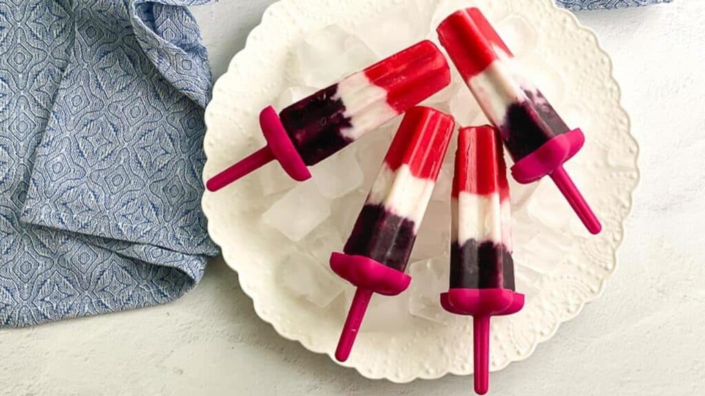 overhead-image-of-vegan-red-white-and-blue-popsicles-on-white-plate.