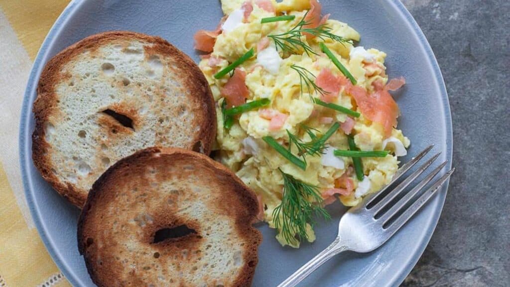 scrambled-eggs-with-smoked-salmon-cream-cheese-chives-nad-dill-on-a-crackled-plate-with-toasted-bagels-2.