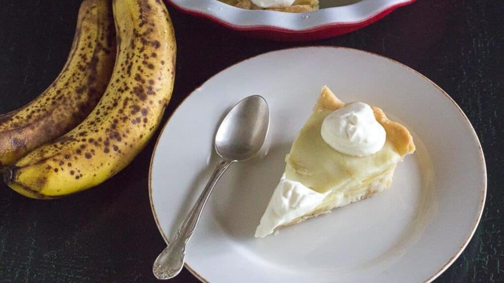 slice-of-low-FODMAP-banana-cream-pie-on-white-plate-with-spoon.