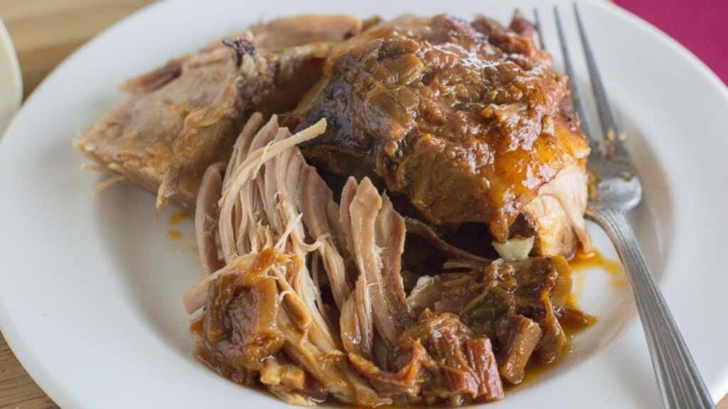 slow-cooked-pork-shoulder-with-rhubarb-BBQ-saice-on-white-plate-with-fork.