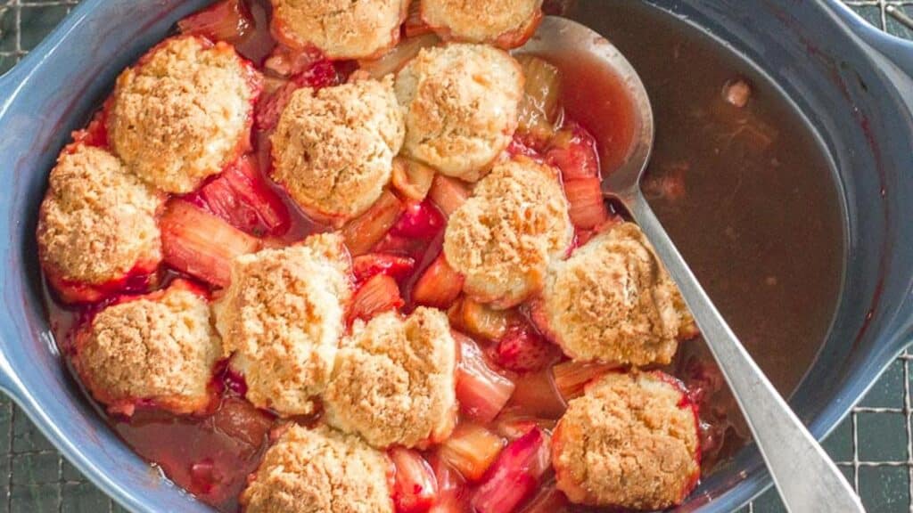 strawberry-rhubarb-cobbler-in-blue-casserole-with-serving-spoon.