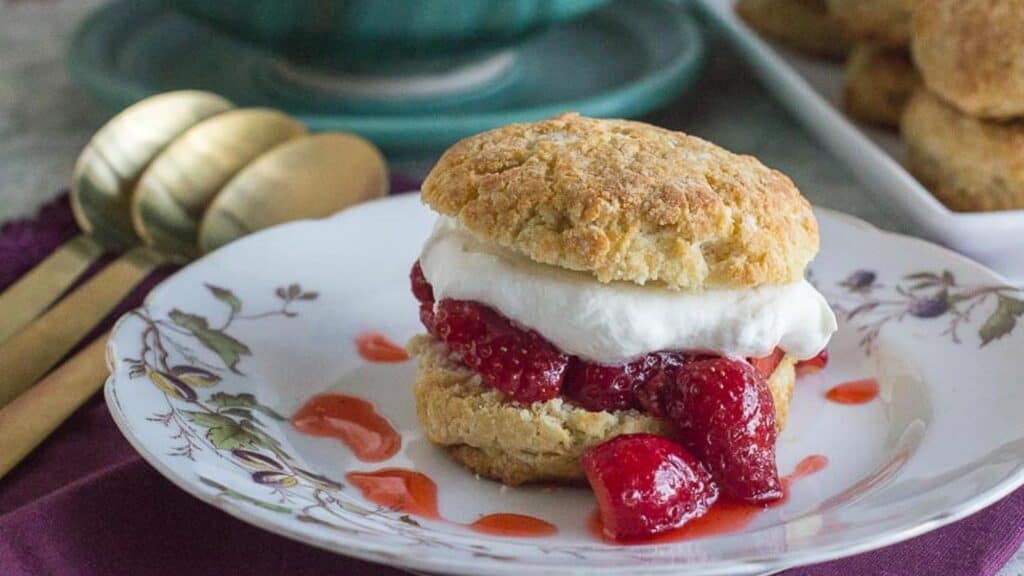 strawberry-shortcake-on-a-white-plate-with-gold-spoons-alongside-2.