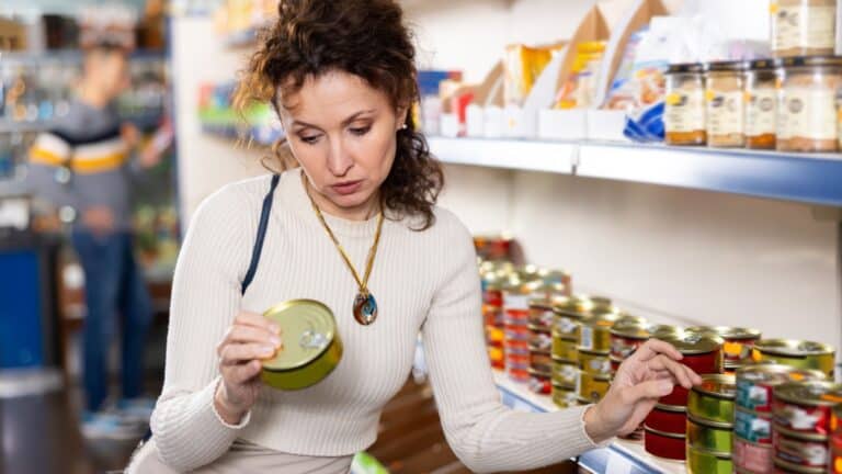 woman buying canned fish.