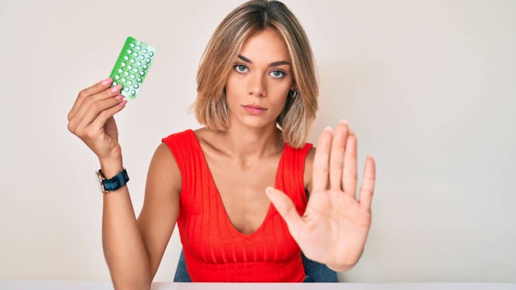 woman holding birth control pills. 