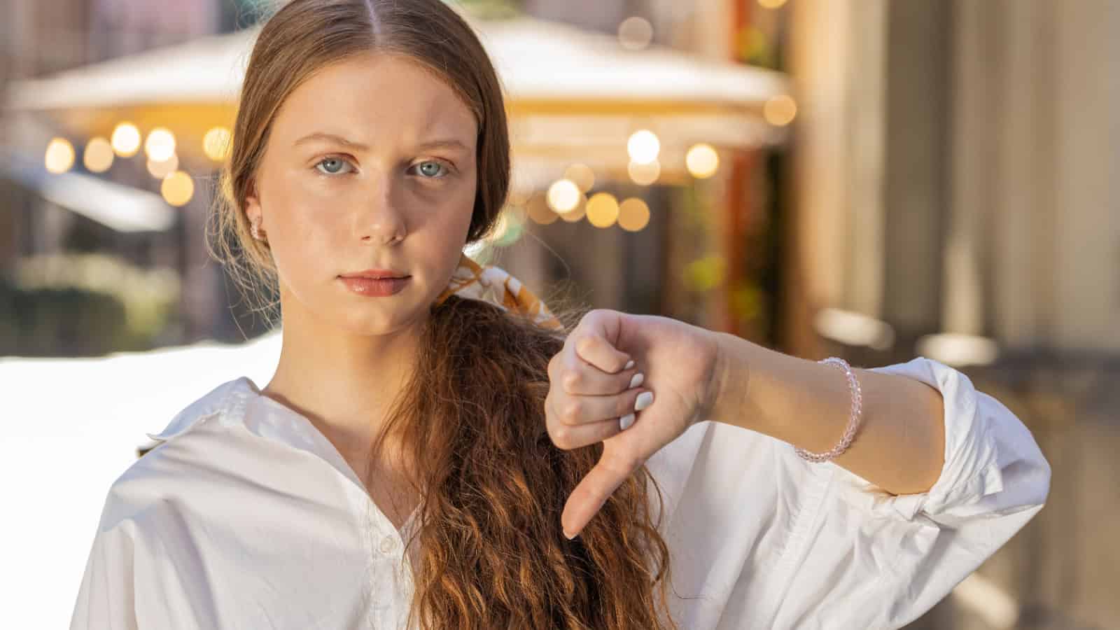 Disapproving teenager, thumbs down.