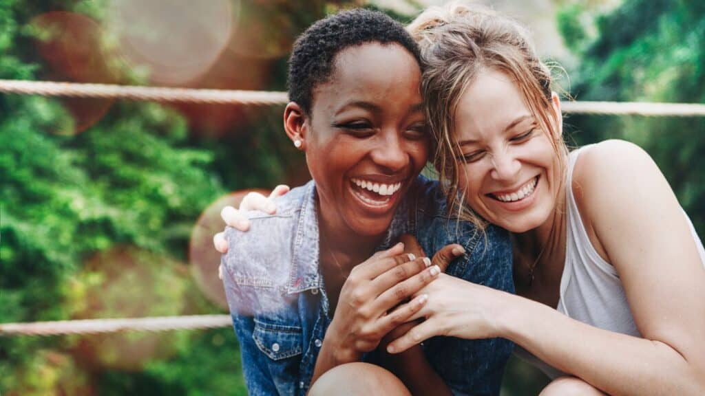 two happy young women embracing or hugging