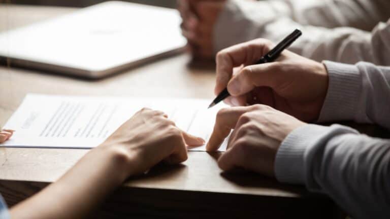 Solicitor pointing at insurance contract showing male client where to write signature sign sale purchase employment agreement at meeting make financial business deal, bank loan service, close up view