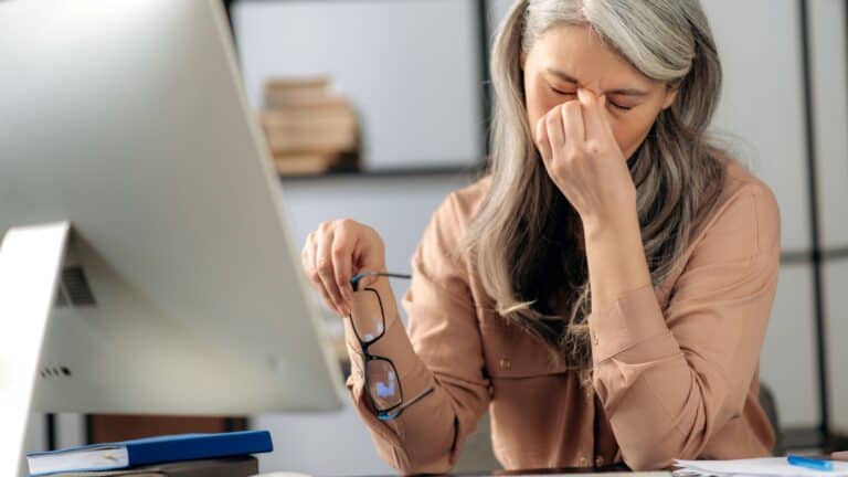 Tired senior woman at work.