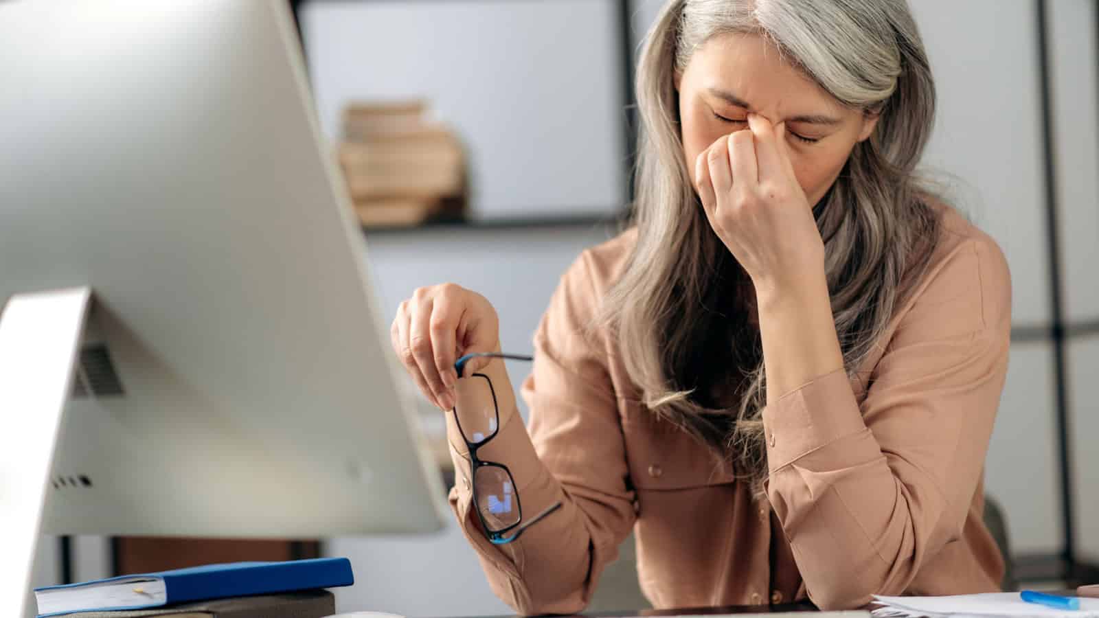 Tired senior woman at work.