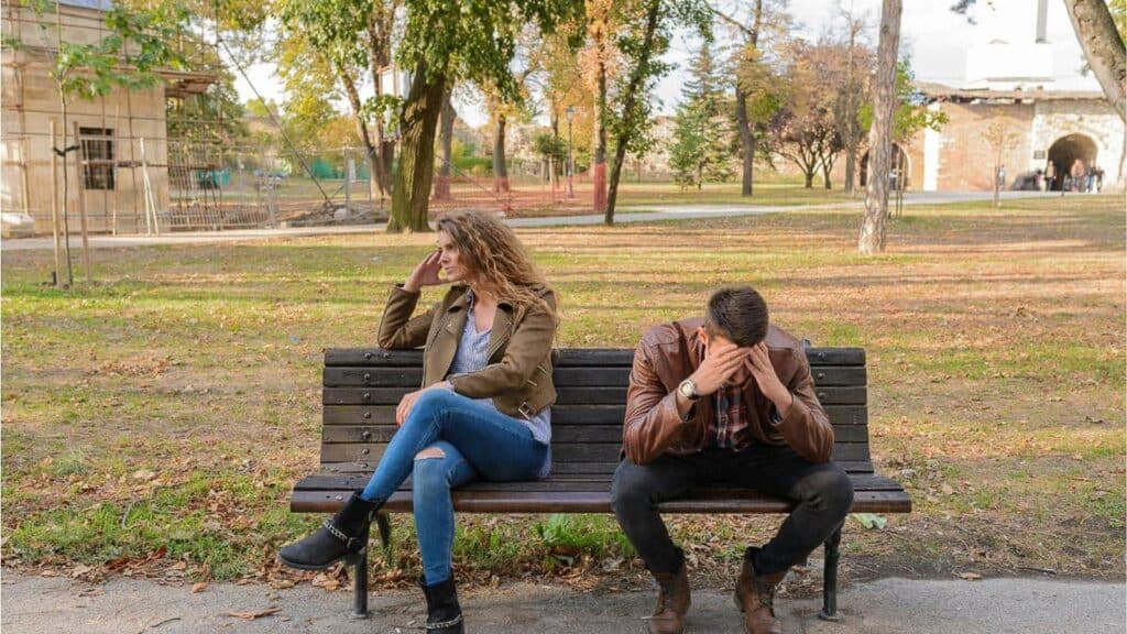 couple-sitting-on-bench-upset.