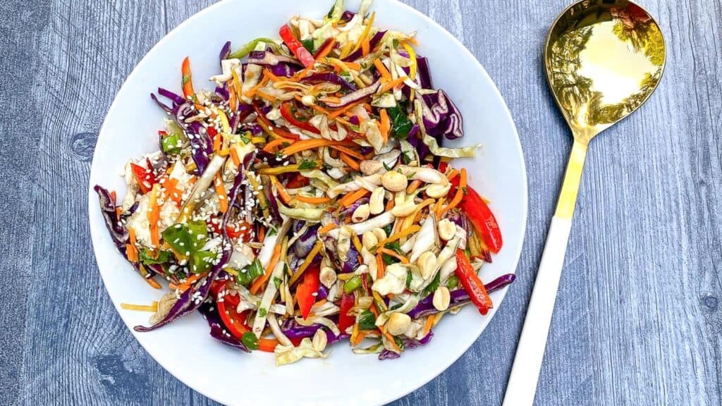 Asian-inspired-slaw-on-white-plate-with-serving-spoon.
