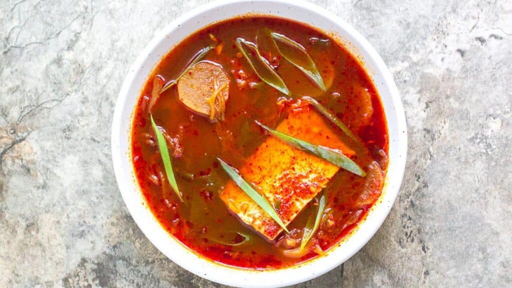 Kimchi-and-Tofu-Stew-in-white-bowl-on-gray-stone-surface-1.
