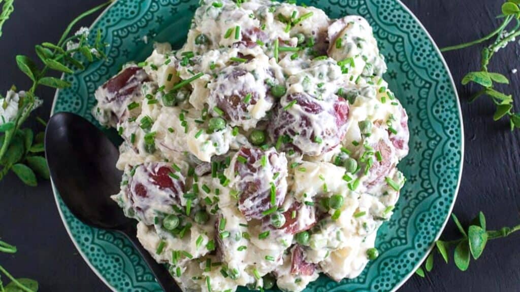 Potato-Salad-with-Peas-Chives-on-a-green-plate.