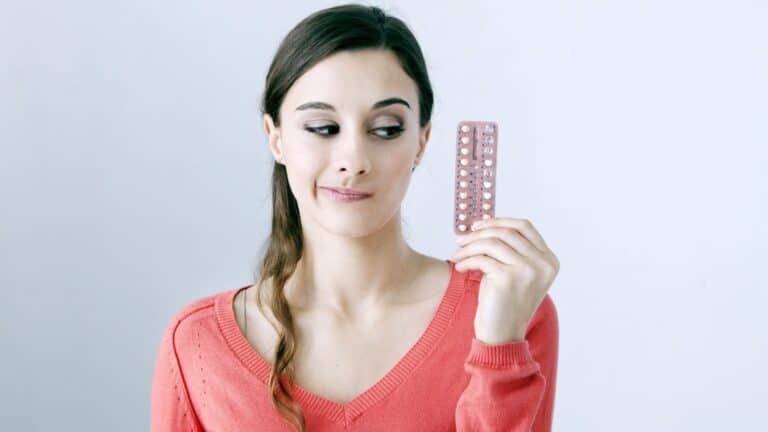 woman holding birth control pills.