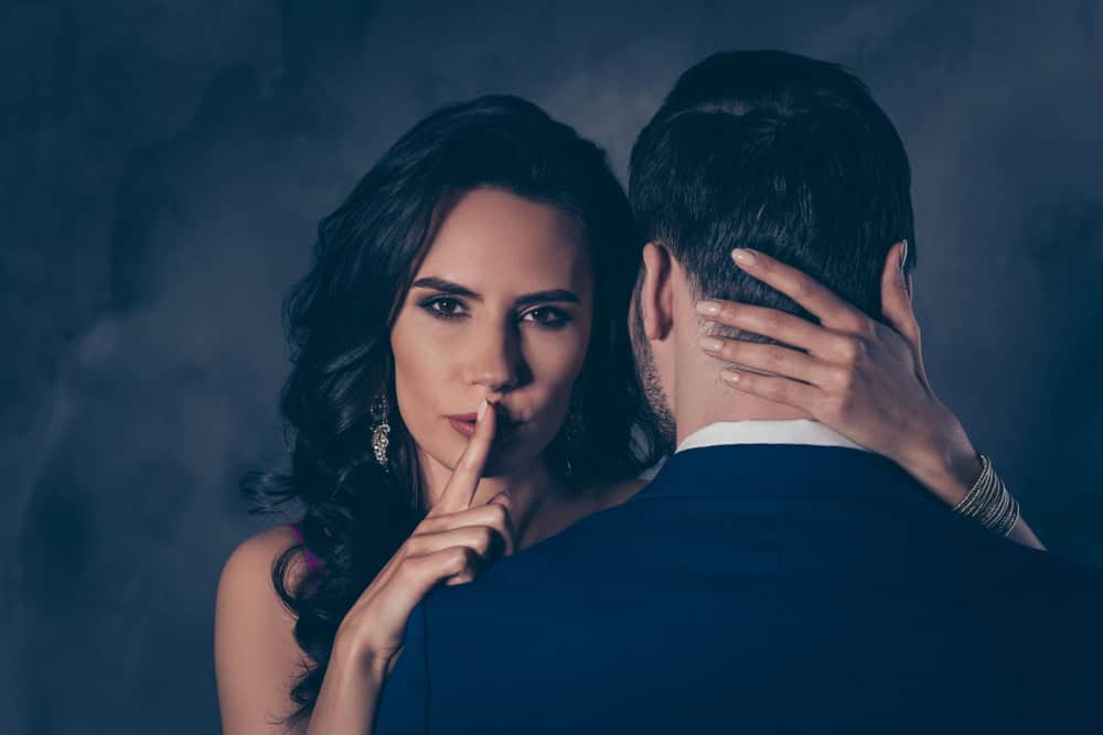 couple - woman saying shhh