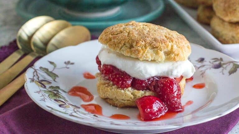 strawberry-shortcake-on-a-white-plate-with-gold-spoons-alongside-2.