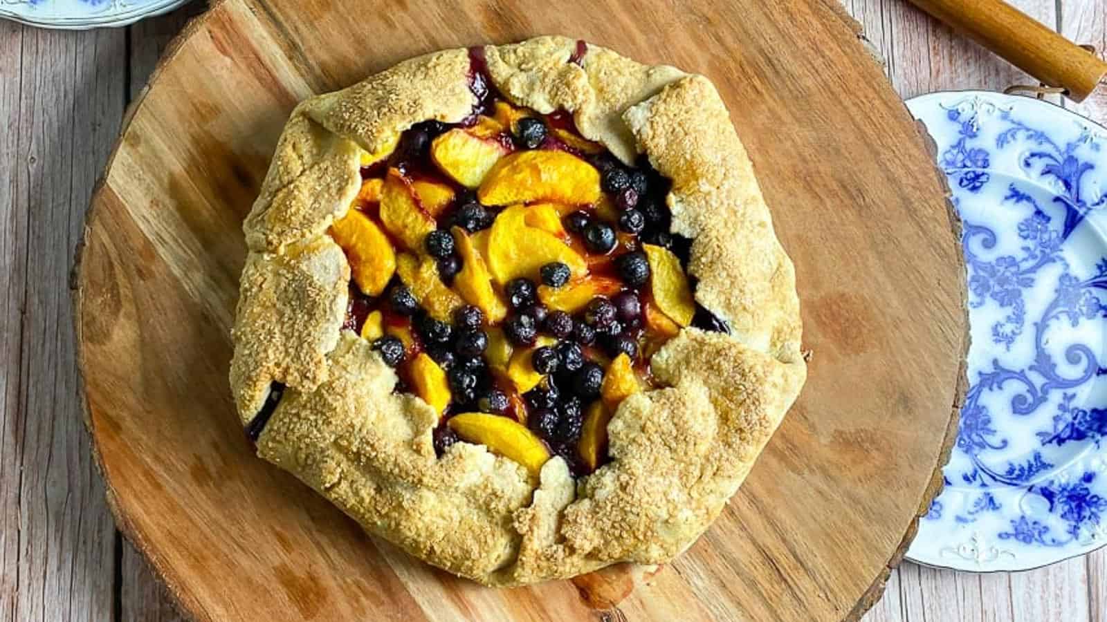 overhead-image-peach-blueberry-crostata-on-wooden-board.