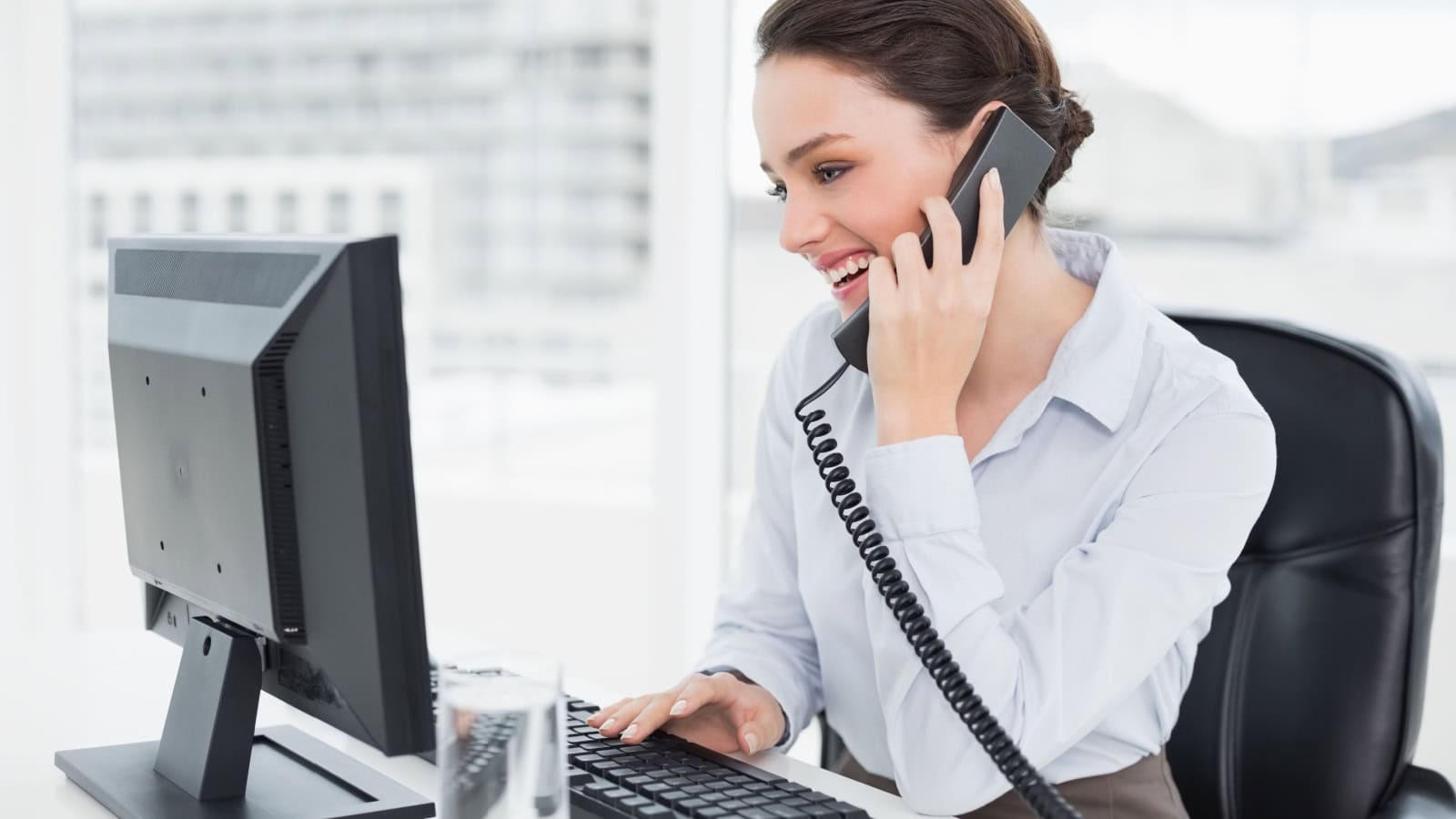 woman in office chair on phone at work.