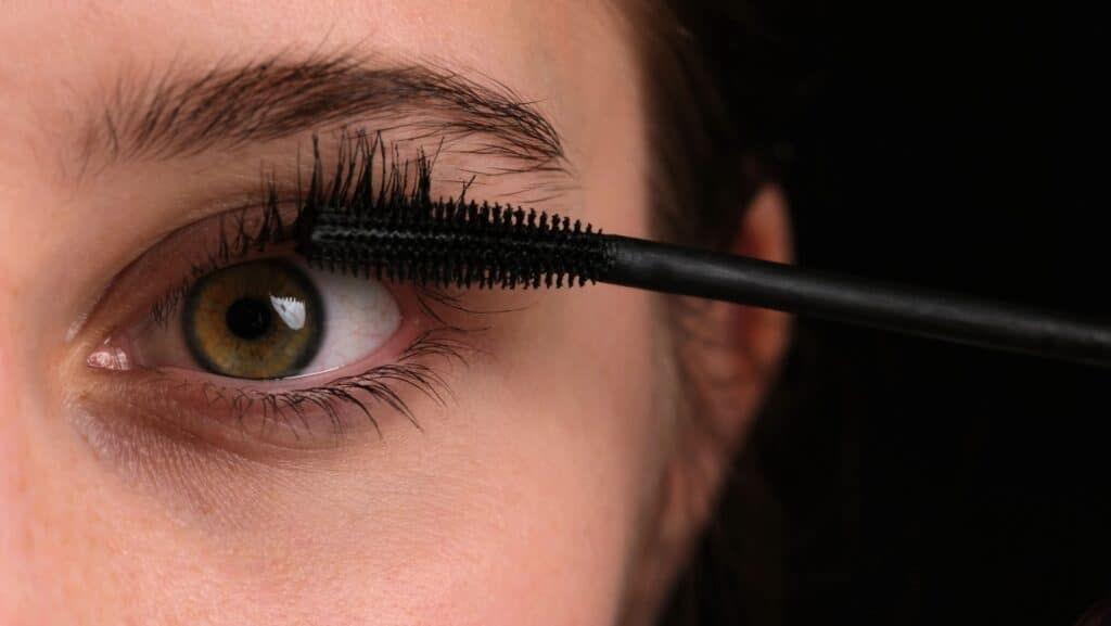 Applying mascara.
