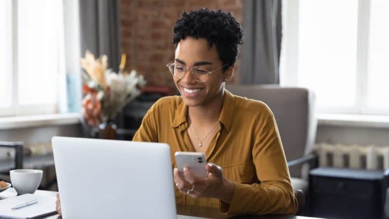 woman at desk laptop and phone.