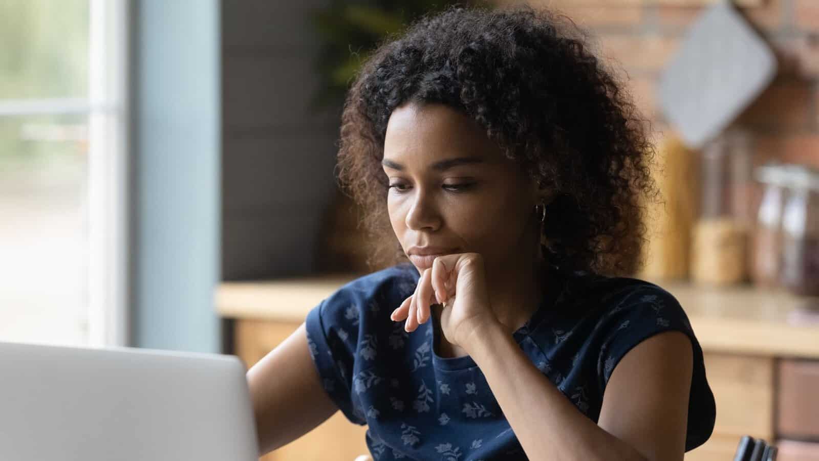 thinking thoughtful woman on laptop computer.