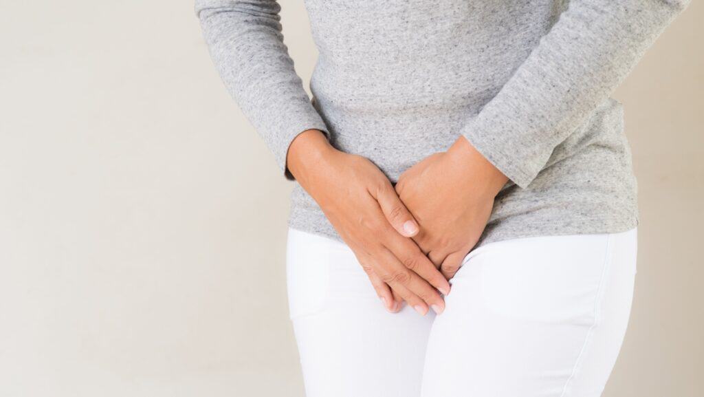 woman holding crotch.