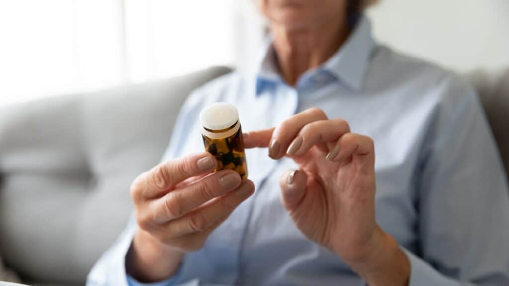 woman reading drug bottle label.