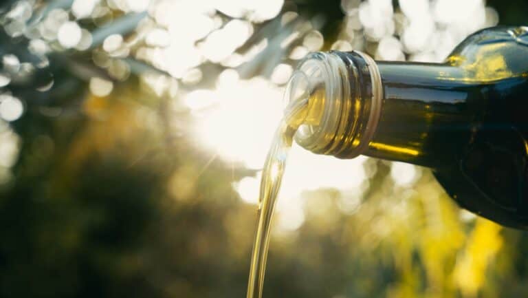 Olive oil pouring out of bottle.