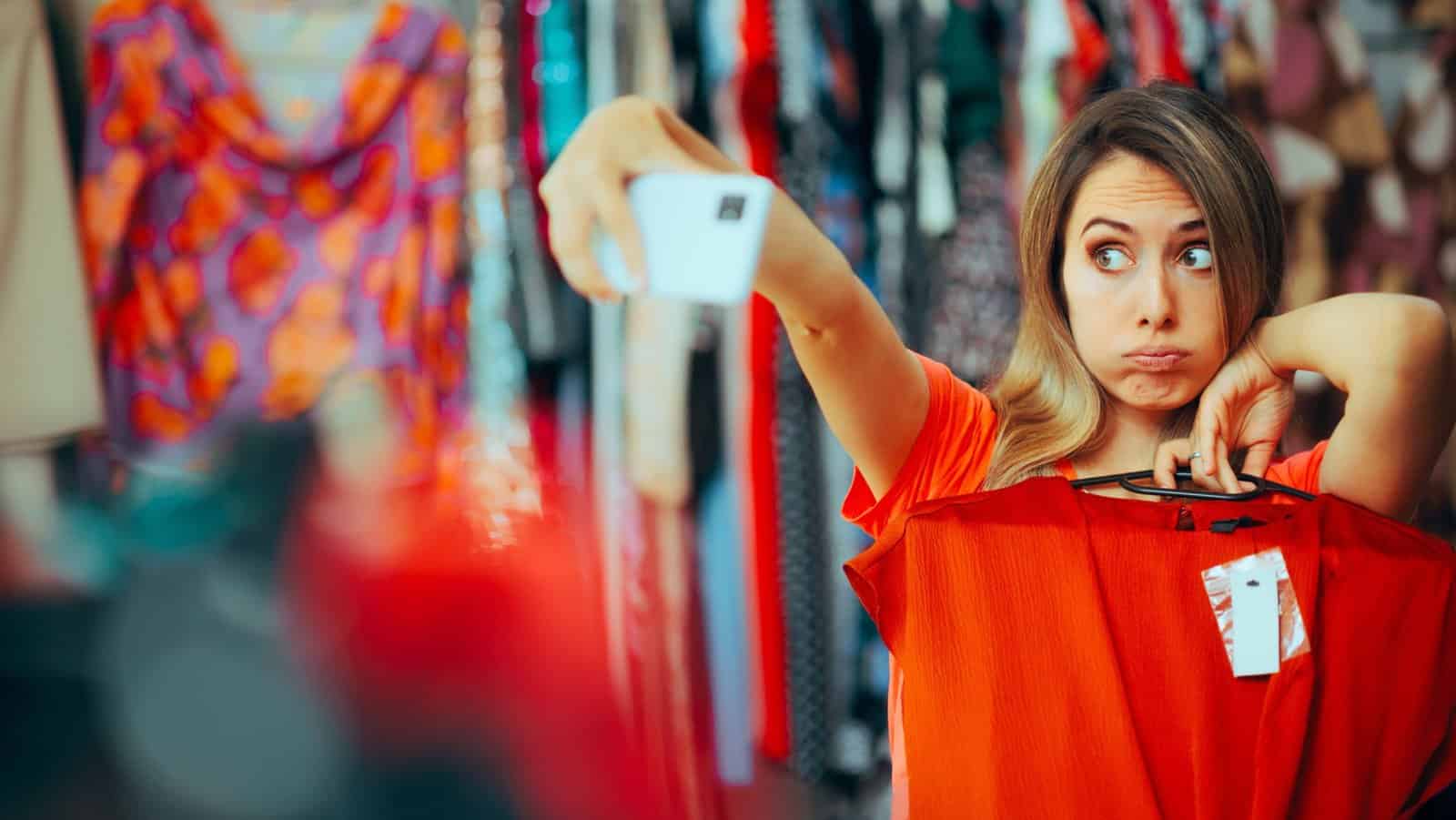 woman taking selfie with clothing.