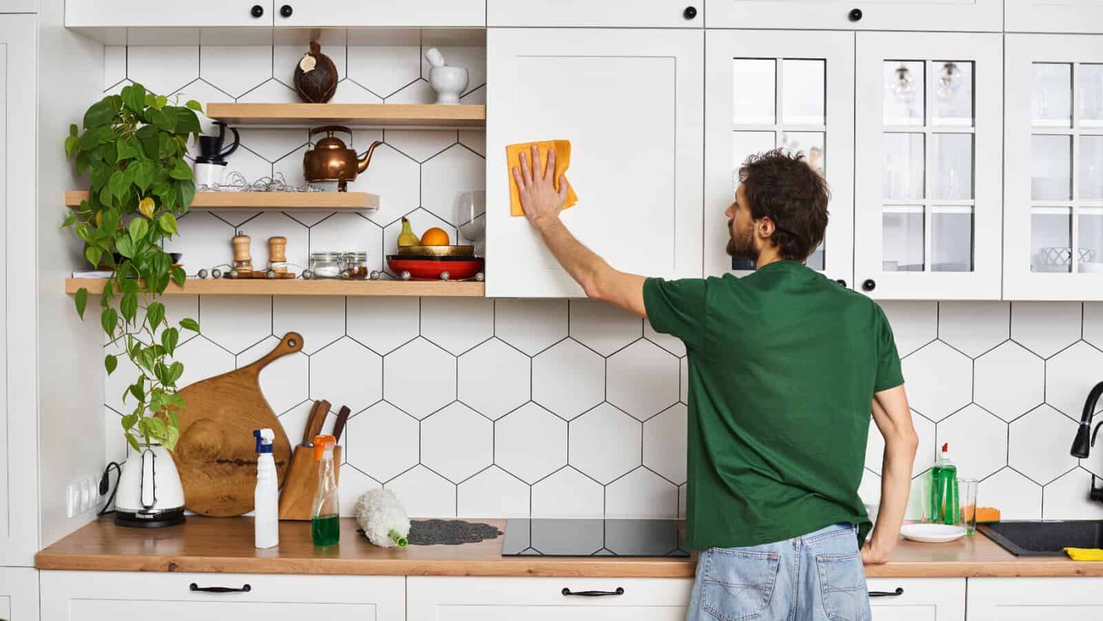 Man cleaning cabinets.