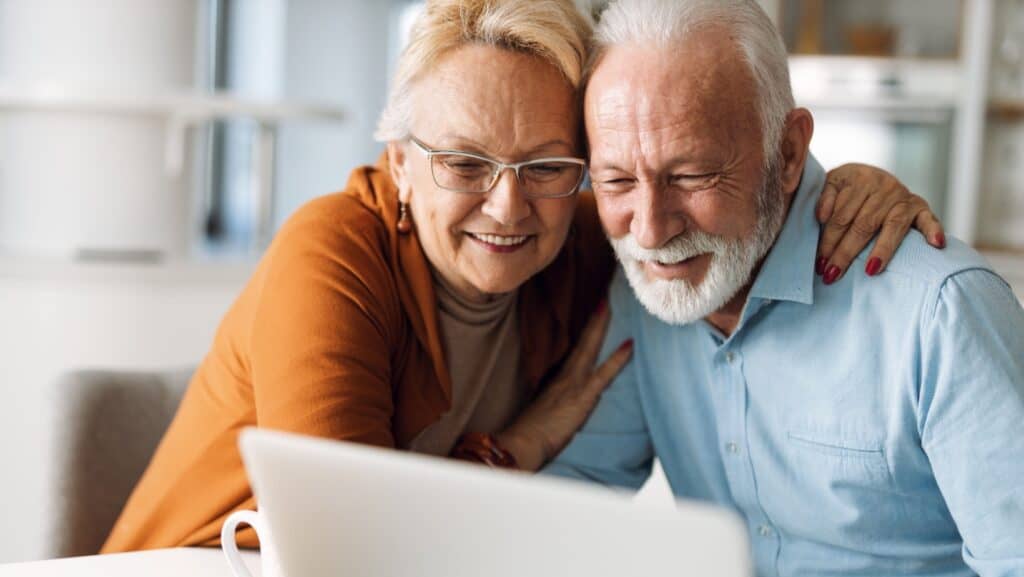 Senior couple looking at laptop computer.