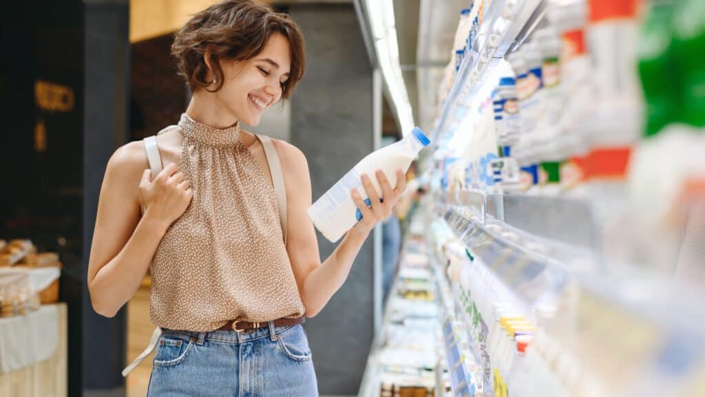 woman buying milk. reading labels. 