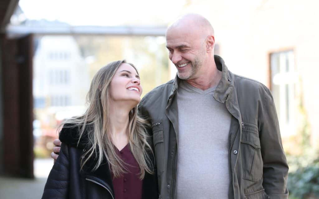 Senior man and young woman look in love