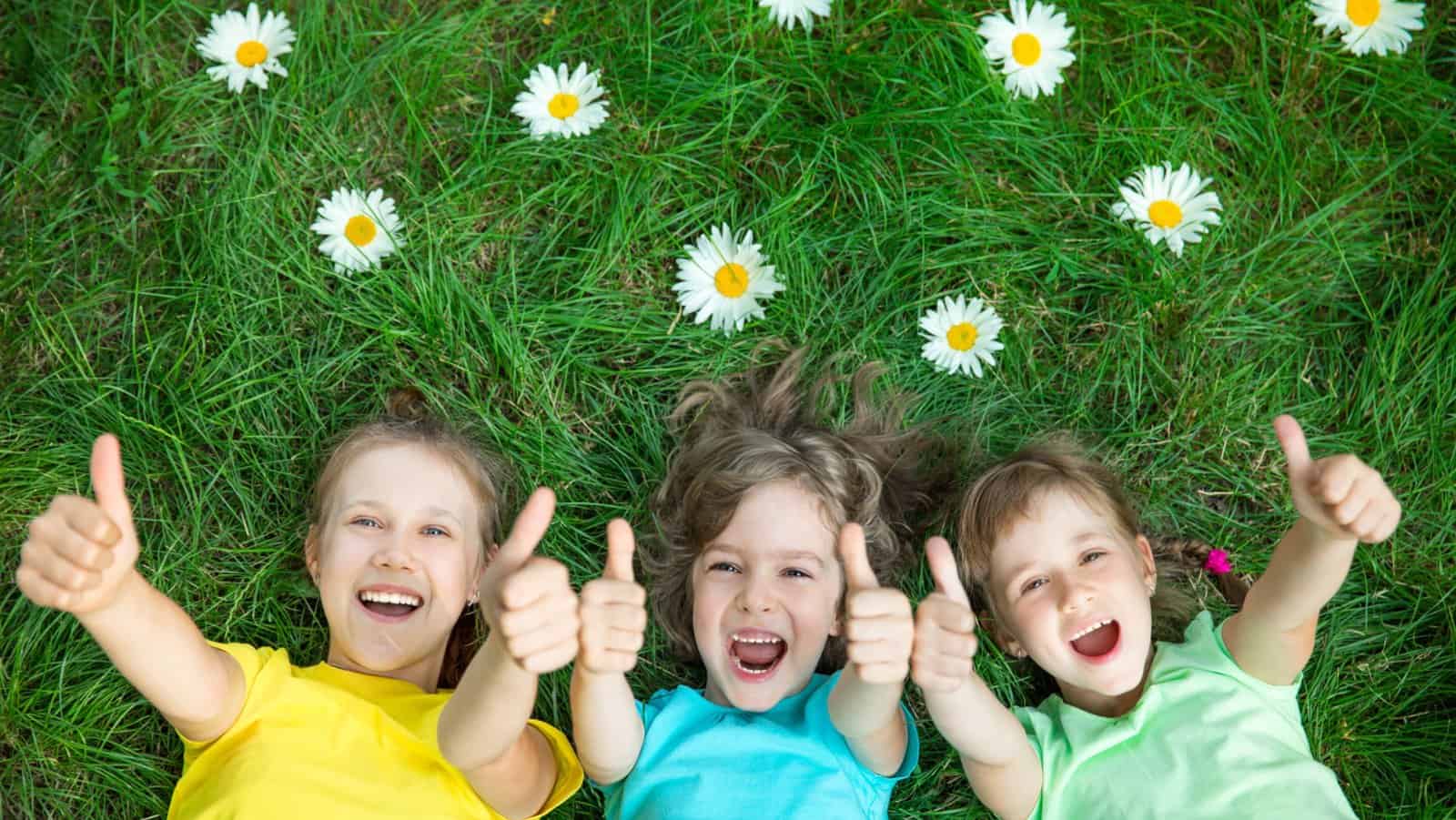 happy kids on grass in spring with flowers.